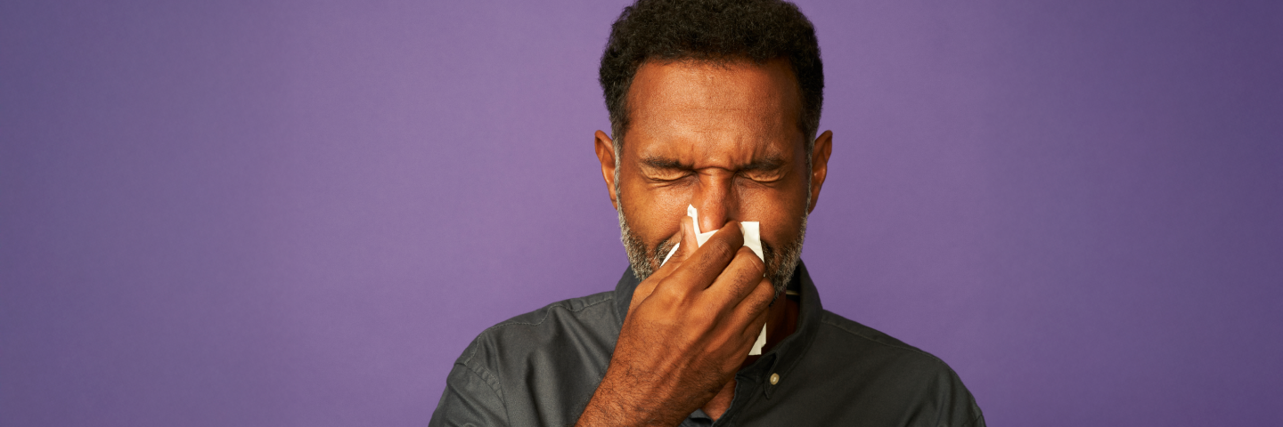 Image depicting a person experiencing sneezing as an allergy symptoms