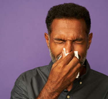 Image depicting a person experiencing sneezing as an allergy symptoms